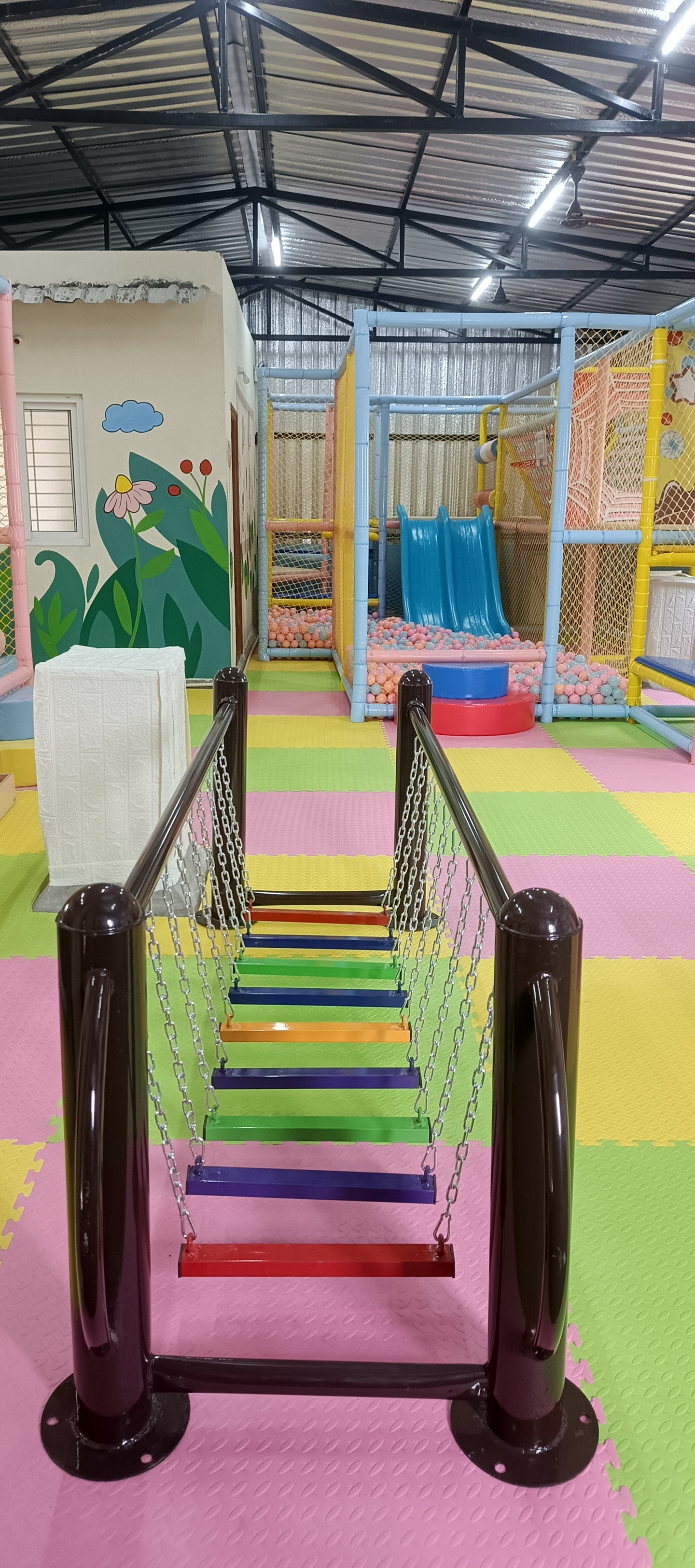 Large ball pit pool with blue slide and soft foam blocks in the indoor play zone