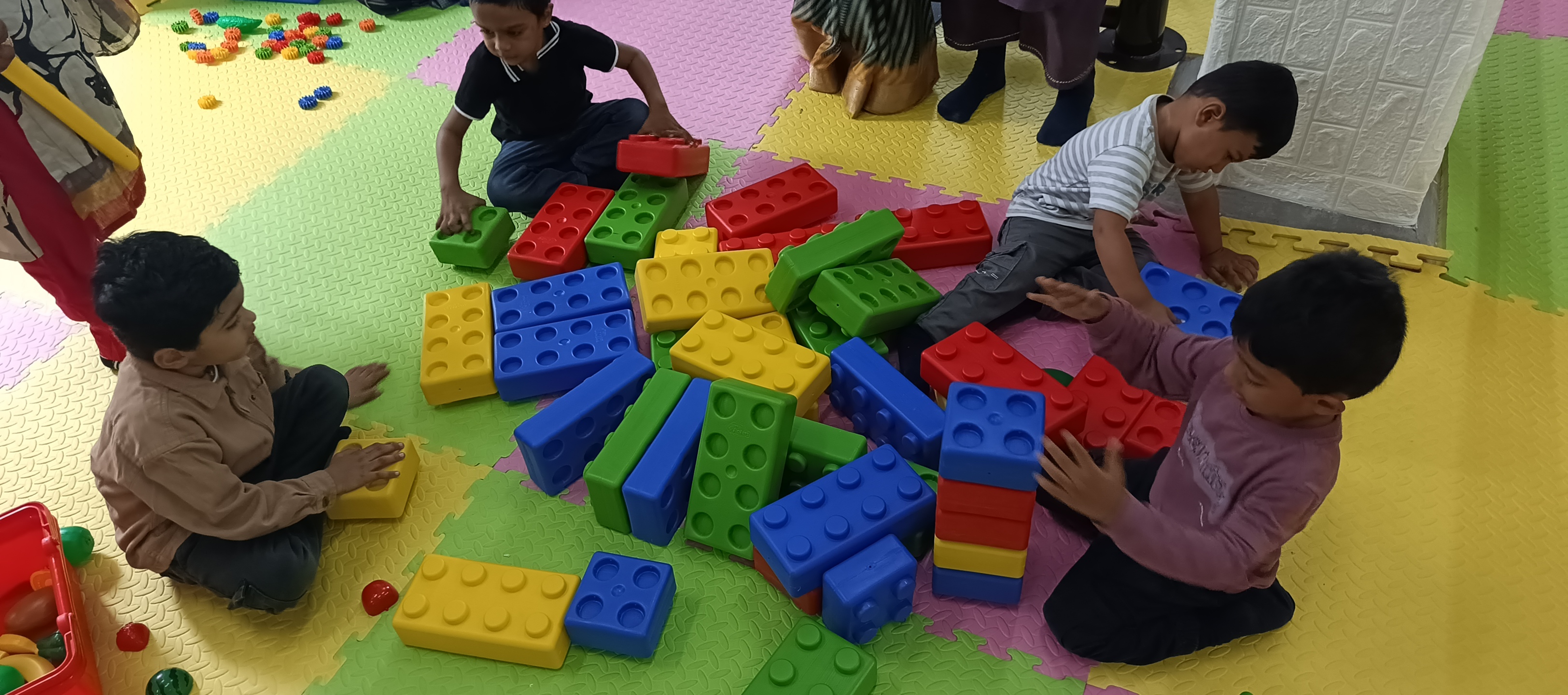 Children working together on huge colorful building block tower